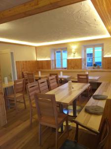 une salle à manger avec des tables et des chaises en bois dans l'établissement Landcafe SIMA & Zimmervermietung, à Forheim