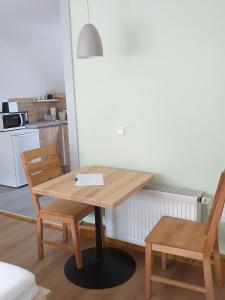 a wooden table and two chairs in a kitchen at Landcafe SIMA & Zimmervermietung in Forheim