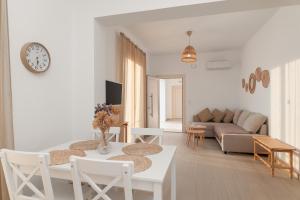 a white living room with a table and a couch at SeaView Apartment 2 in Samos