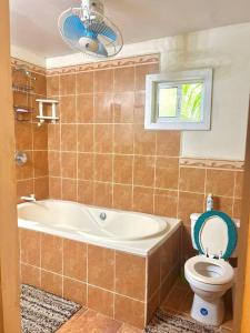 baño con bañera, aseo y ventana en Island style home, low key rental en Roatan