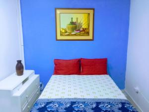 Habitación azul con cama con almohadas rojas en Makako Chillout Hostel, en Cartagena de Indias