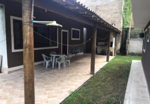 eine Terrasse eines Hauses mit einem Tisch und Stühlen in der Unterkunft Casa dona Eliane Temporada Tarituba Paraty in Tarituba