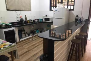 eine kleine Küche mit einer Theke und einem Kühlschrank in der Unterkunft Casa dona Eliane Temporada Tarituba Paraty in Tarituba
