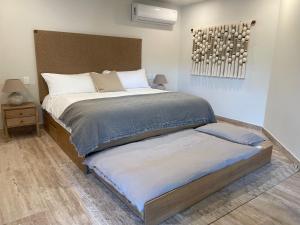 a bedroom with a large bed with a headboard at Luxury Stay at AWA Playacar 3BR Designer Condo in Playa del Carmen