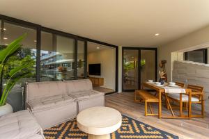 a living room with a couch and a table at Luxury Stay at AWA Playacar 3BR Designer Condo in Playa del Carmen