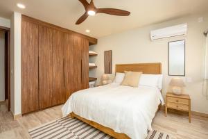 a bedroom with a bed and a ceiling fan at Luxury Stay at AWA Playacar 3BR Designer Condo in Playa del Carmen +31 photos