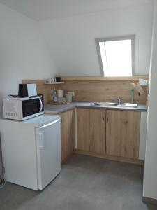 a kitchen with a microwave and a sink at Landcafe SIMA & Zimmervermietung in Forheim