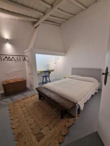 1 dormitorio con cama y banco. en Casa de Santa Margarida, en Mourão