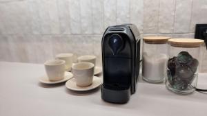 a toaster sitting on top of a counter with cups at Apartament Ogrodowa in Łódź