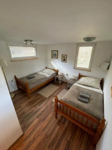a bedroom with two beds and two windows at Riverhouse apartment in Radovljica