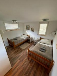 a bedroom with two beds and two windows at Riverhouse apartment in Radovljica +11 photos
