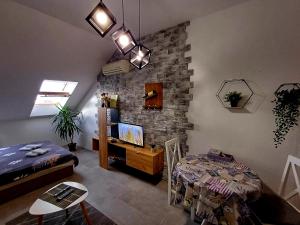 ein Wohnzimmer mit einem Bett und einem Tisch mit einem TV in der Unterkunft Apartment Centrum - Free private parking in Novi Sad