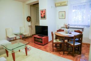 een woonkamer met een tafel en een televisie bij SkopjePad - Centrally Located, Stylish Pad in Skopje