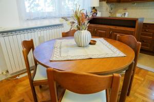 Una mesa de comedor con un jarrón de flores encima. en SkopjePad - Centrally Located, Stylish Pad, en Skopje
