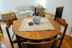 Una mesa de madera con un jarrón de flores encima. en SkopjePad - Centrally Located, Stylish Pad, en Skopje 15 fotos más