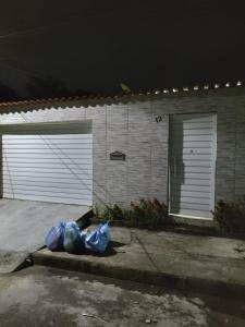 una bolsa de plástico sentada frente a un garaje por la noche en Casa com piscina, en Camaçari