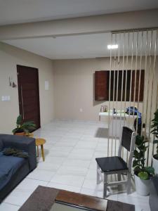 ein Wohnzimmer mit einem Sofa und einem Tisch in der Unterkunft Casa com piscina in Camaçari