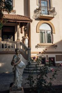 a statue of a woman in front of a building at Veritas Boutique Vila in Craiova