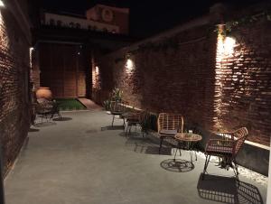 un patio con sedie, tavoli e un muro di mattoni di Precioso estudio en el centro de Málaga 1 a Málaga