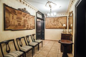 una habitación con sillas y una pintura en la pared en Veritas Boutique Vila en Craiova