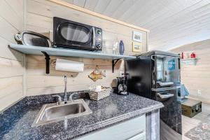 a kitchen with a sink and a microwave at Something Fishy at Island Breeze of CB in Carolina Beach +14 photos