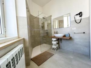 uma casa de banho com uma cabina de duche em vidro e um lavatório. em MAISON NOEL em Trieste