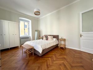 um quarto com uma cama e piso em madeira em MAISON NOEL em Trieste