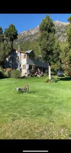 un patio con una casa y un árbol en El paraíso farmhouse en Cholila