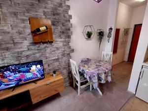 a dining room with a table and a stone wall at Apartment Centrum - Free private parking in Novi Sad