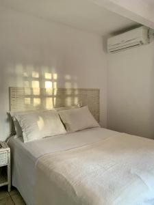 a white bed with white pillows in a bedroom at Itacaré Flats in Itacaré