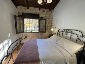 a bedroom with a bed in a room with a window at Vista Mora Sierra Cazorla in La Iruela