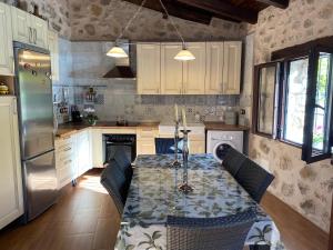 a kitchen with a table with chairs and a refrigerator at Vista Mora Sierra Cazorla in La Iruela