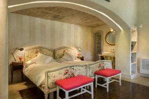 ハライス・デ・ラ・ベラにあるVaqueria Cantaelgalloのベッドルーム1室(大型ベッド1台、赤い椅子2脚付)