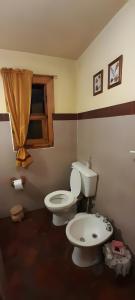 uma casa de banho com um WC e um lavatório em El paraíso farmhouse em Cholila