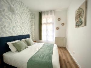 sypialnia z łóżkiem z niebieskim zagłówkiem i oknem w obiekcie Central Park w mieście Serris