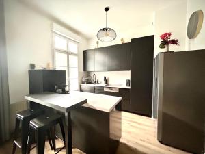 a kitchen with black cabinets and a table with stools at Central Park in Serris