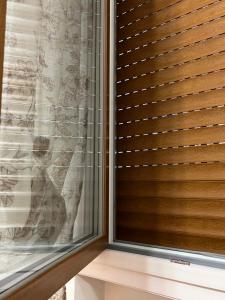 a window with wooden blinds in a room at AT HOME Mogliano come a casa ma in vacanza in Mogliano Veneto