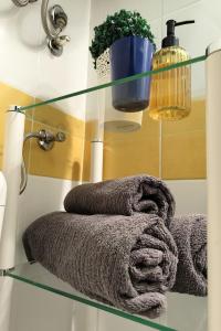 a glass shelf with towels on it in a bathroom at Robins Nest in The City Center in Maribor