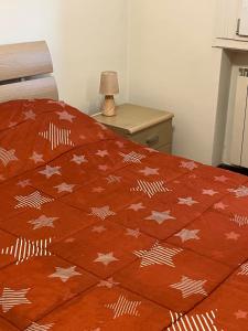 a bed with a red comforter with stars on it at AT HOME Mogliano come a casa ma in vacanza in Mogliano Veneto