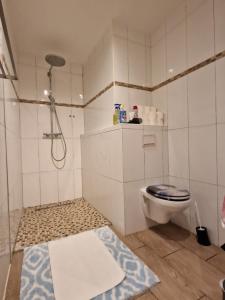 a white bathroom with a toilet and a shower at Ferienhaus Vio 