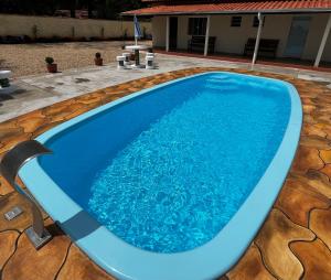 a large blue swimming pool on a patio at Chácara Barone - Chácara em SerraNegra in Serra Negra
