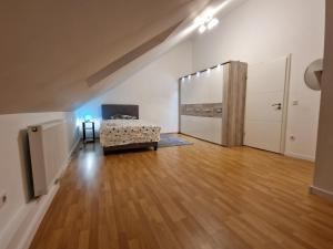uma sala de estar com uma cama e um piso de madeira em Ferienhaus Vio 