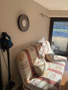 a living room with a couch and a clock on the wall at Appartement 4 personnes Plat d'Adet - Résidence "Le grand Schuss" - Appt 1208 in Saint-Lary-Soulan