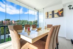a dining room with a table and chairs and a large window at Unique Villa Scandinavia Marbella in Marbella