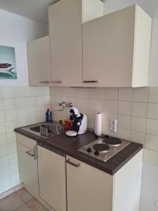 a kitchen with white cabinets and a stove top oven at Seeapartment am Ossiacher See am Fuße der Gerlitzen in Stiegl