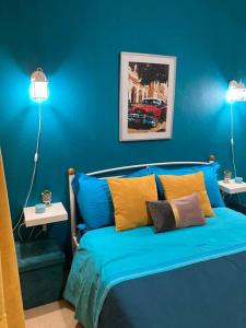 a blue bedroom with a bed with two lights on at Retro living apartment in Larisa