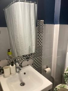 a bathroom with a sink and a shower curtain at Retro living apartment in Larisa