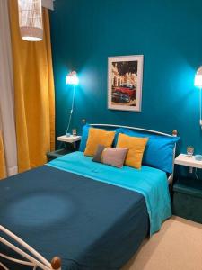 a blue bed in a blue bedroom with two lamps at Retro living apartment in Larisa