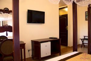 1 dormitorio con 1 cama y TV en la pared en Island Paradise Inn en Ngambo