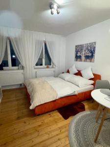 a bedroom with a bed and a table and windows at GoldMol Nuremberg Old Town in Nuremberg